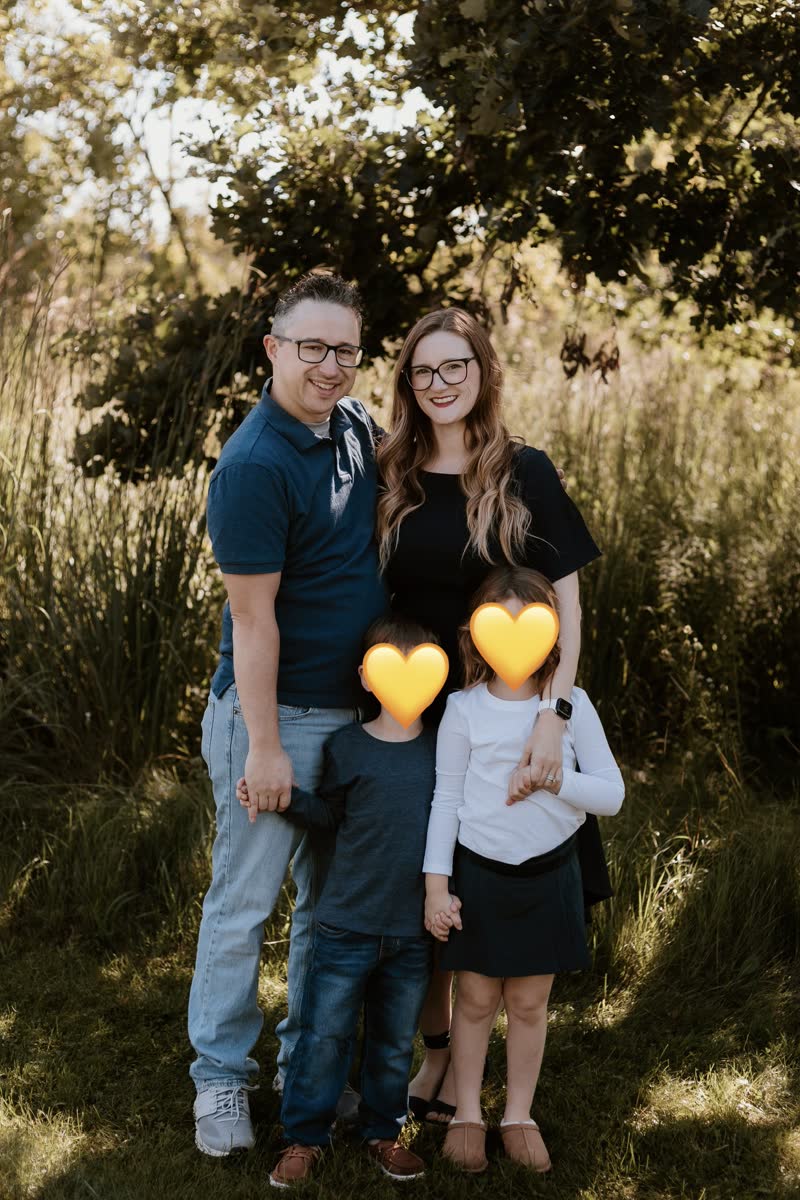 Mercedes Lawson with her family outdoors; children&rsquo;s faces covered with hearts